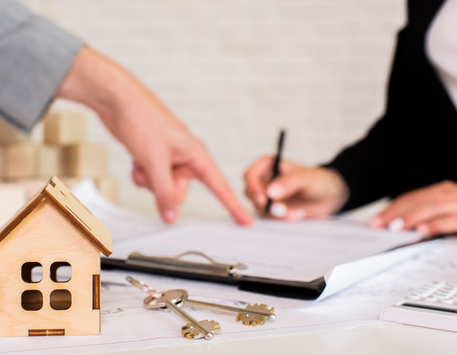 Signature d’un contrat immobilier avec un agent et des clés sur la table