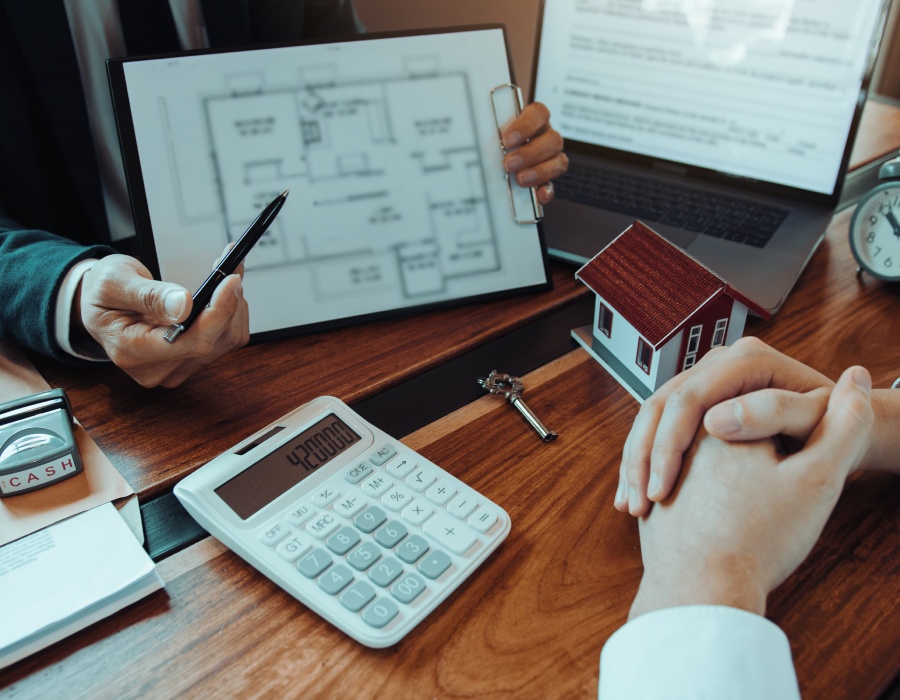 Conseiller immobilier présentant un plan et évaluant un projet de vente ou d’achat